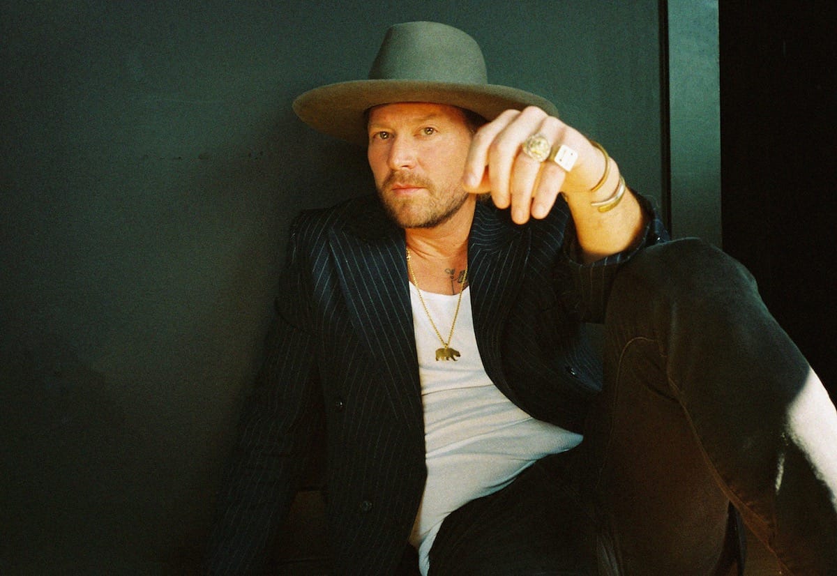 Wilder Woods sits against a green wall