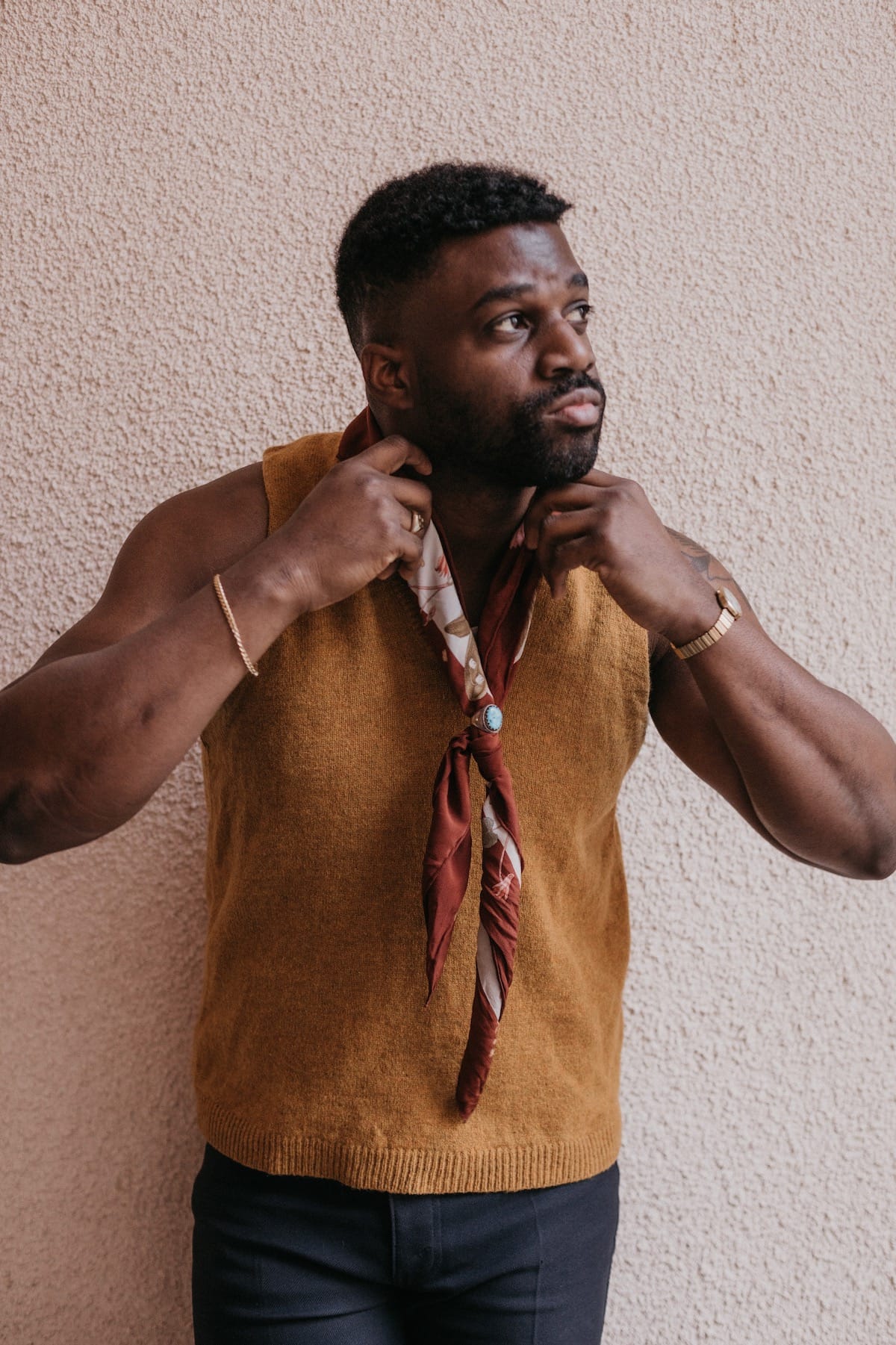 Abraham Alexander adjusts his scarf while looking upward