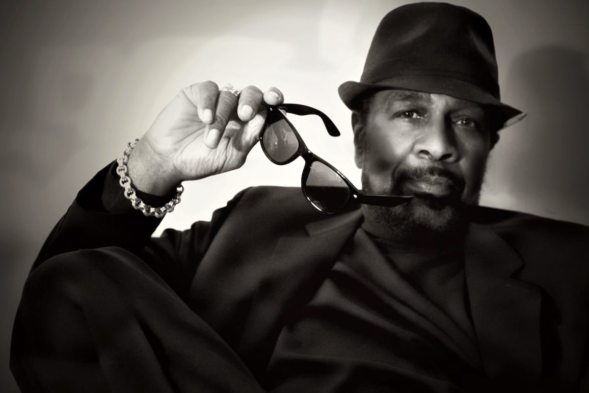 Black and white photo of William Bell wearing hat and holding sunglasses