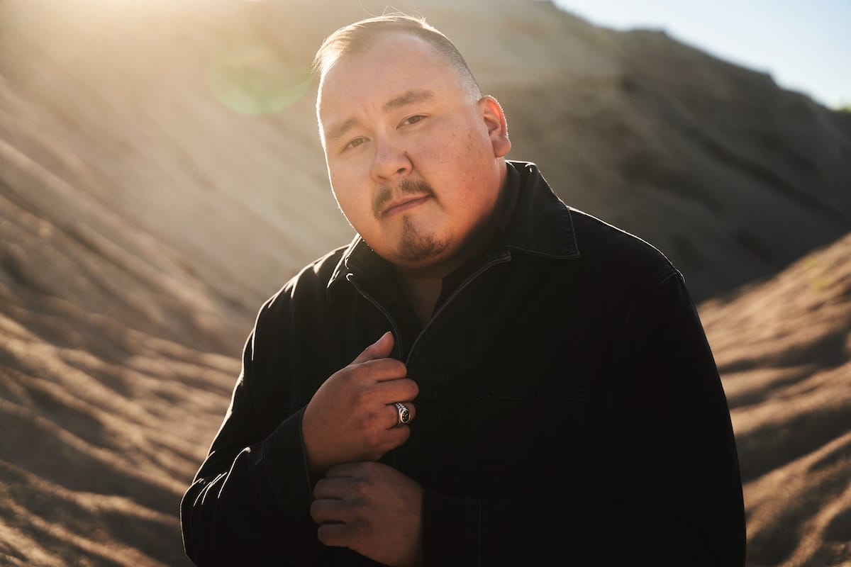 William Prince in a black shirt with a sunlit mountain background