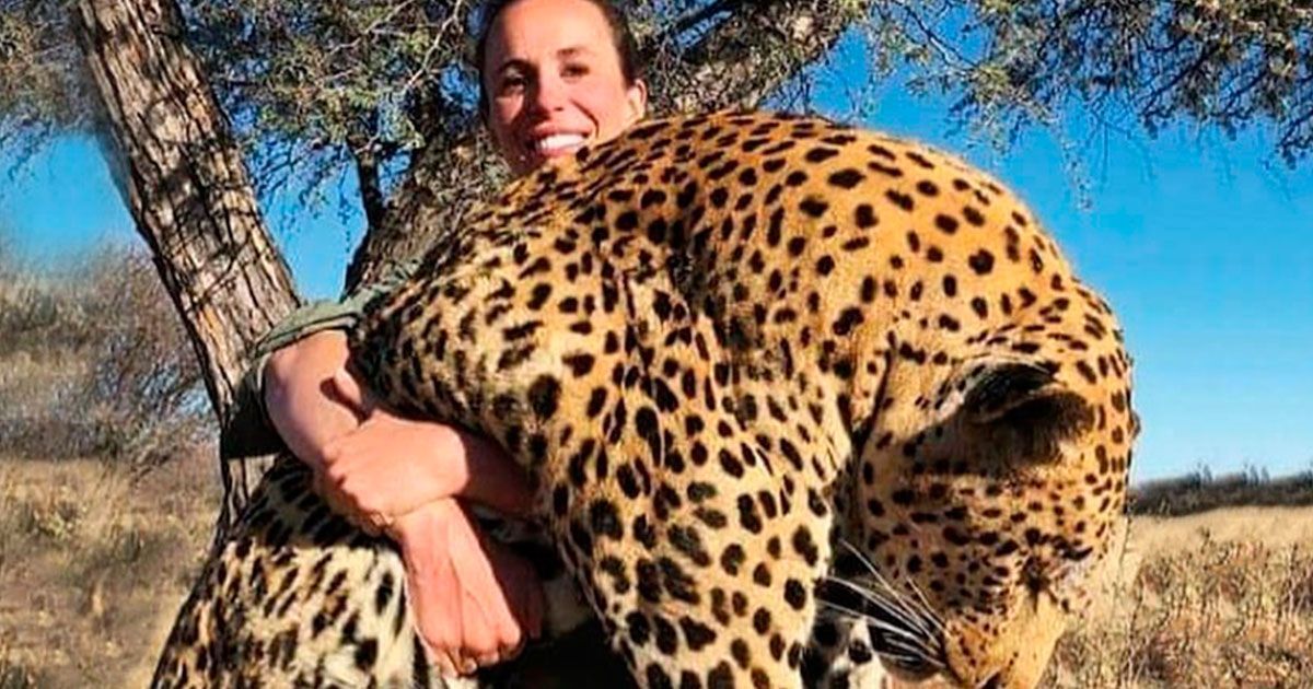 Cazadora posa con un leopardo muerto en sus brazos