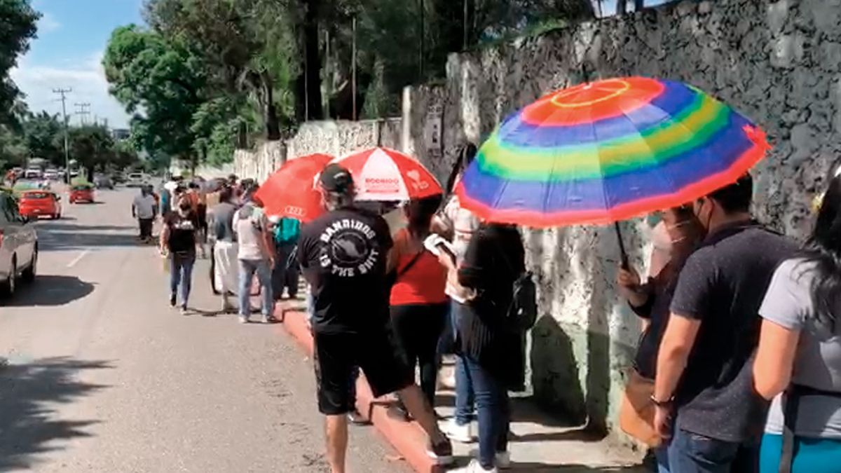 Mamás apartan lugar en fila de vacunación a sus hijos treintañeros