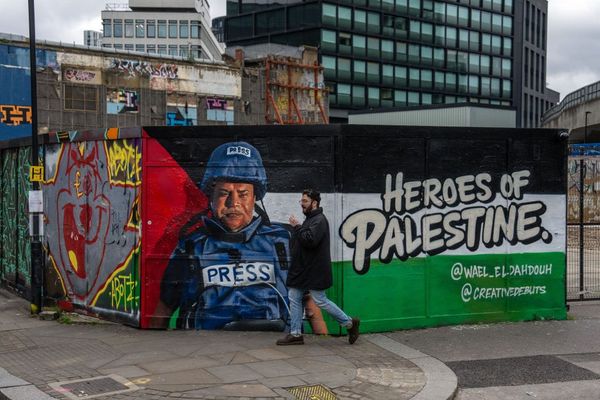 A man walks past graffiti titled 'Heroes of Palestine' featuring a picture of Palestinian journalist Wael Al-Dahdouh on January 30, 2024 in London, United Kingdom