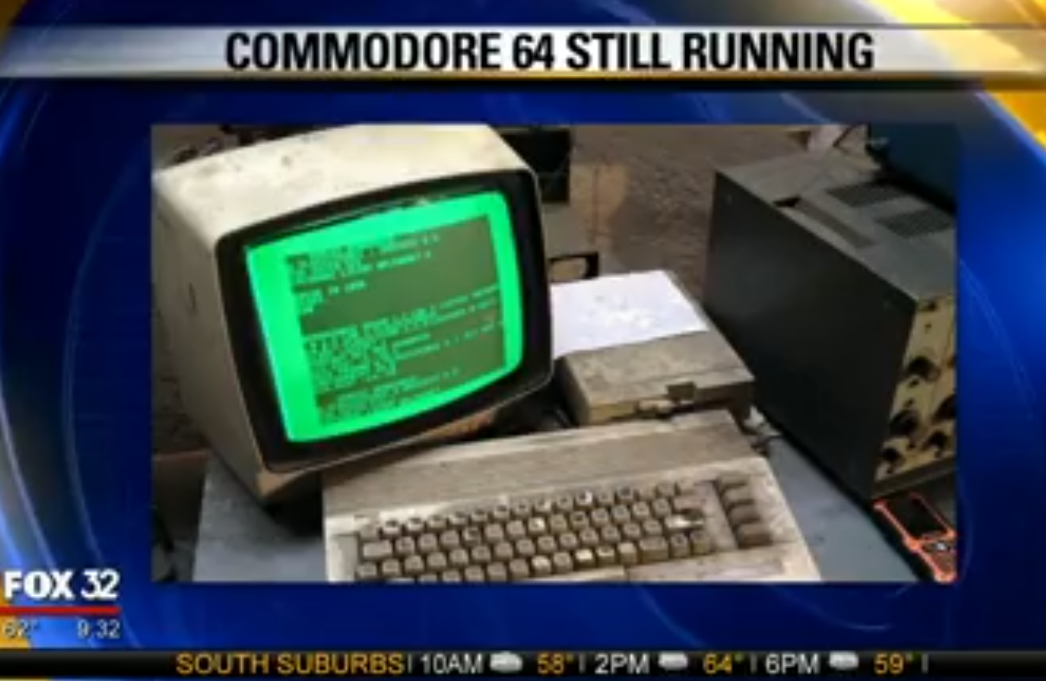 Screen capture from a news program that ran on FOX 32 (not sure what state). The chyron along the top reads, "Commodore 64 still running" and is accompanied by a photo of a C64C with floppy drive and green, monochrome monitor. The units are covered in thick grime and seem genuinely unpleasant to touch without a lot of disinfectant afterward.