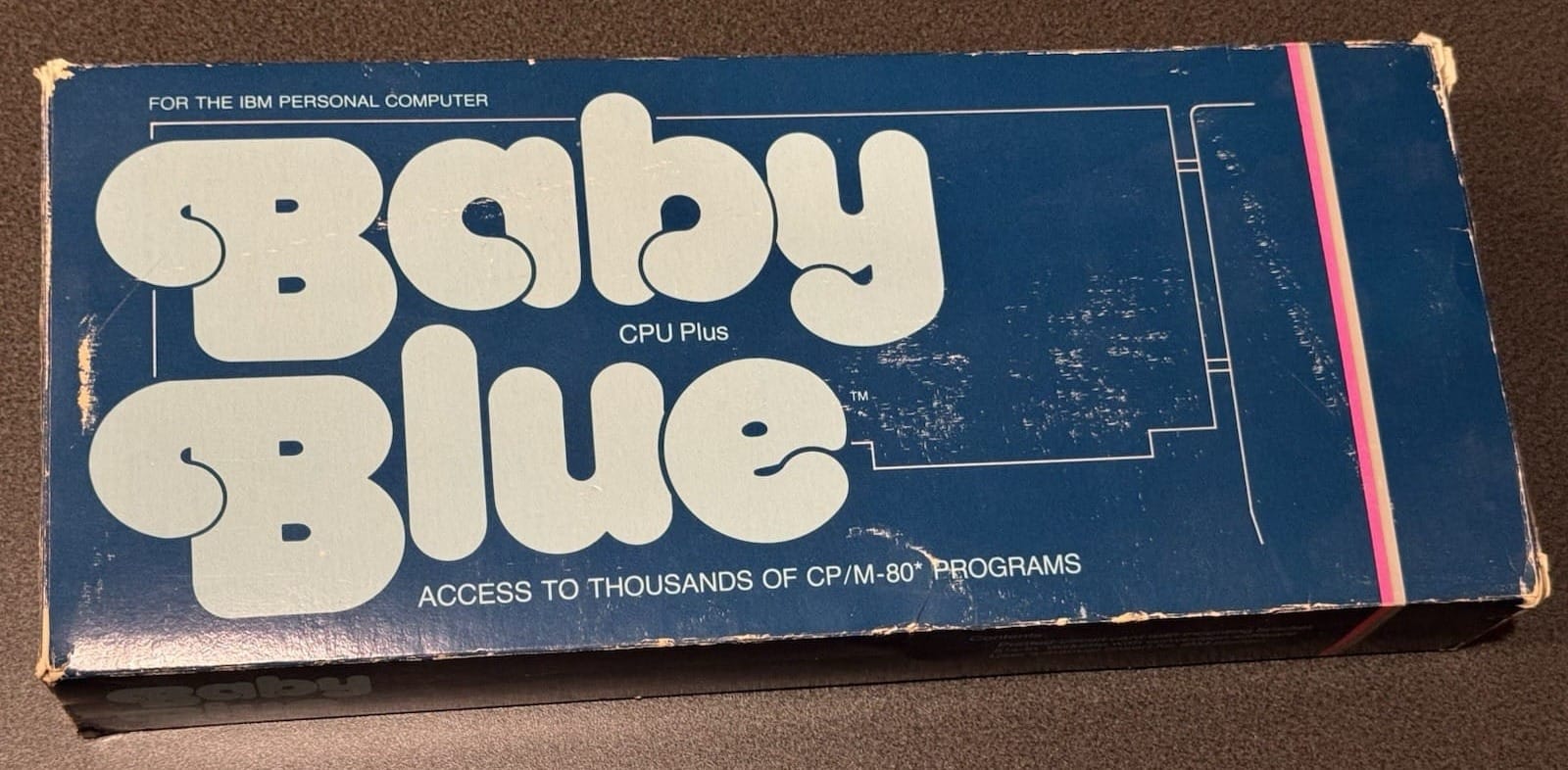 Retail box for “Baby Blue” CPU Plus for the IBM Personal Computer. The blue cardboard packaging features large white bubble lettering reading “Baby Blue” and the tagline “Access to thousands of CP/M-80 programs,” with visible shelf wear and scuffing along the edges.
