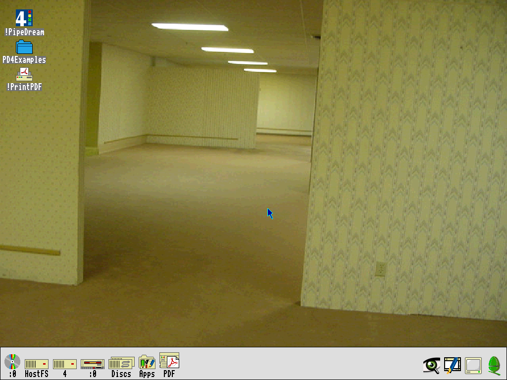 Screenshot of RISC OS 3.7 running. The desktop wallpaper has been set to a famous image of yellow walls and carpeting, that started the "Backrooms" meme. Icons for PipeDream and PDF printing are on the main desktop. The icon bar at the bottom has icons for various disks attached on the left, and on the right are the running apps, like monitor resolution setting, and image preview. The Acorn logo sits in the bottom right, akin to the Apple logo in the upper left menu on Mac OS.