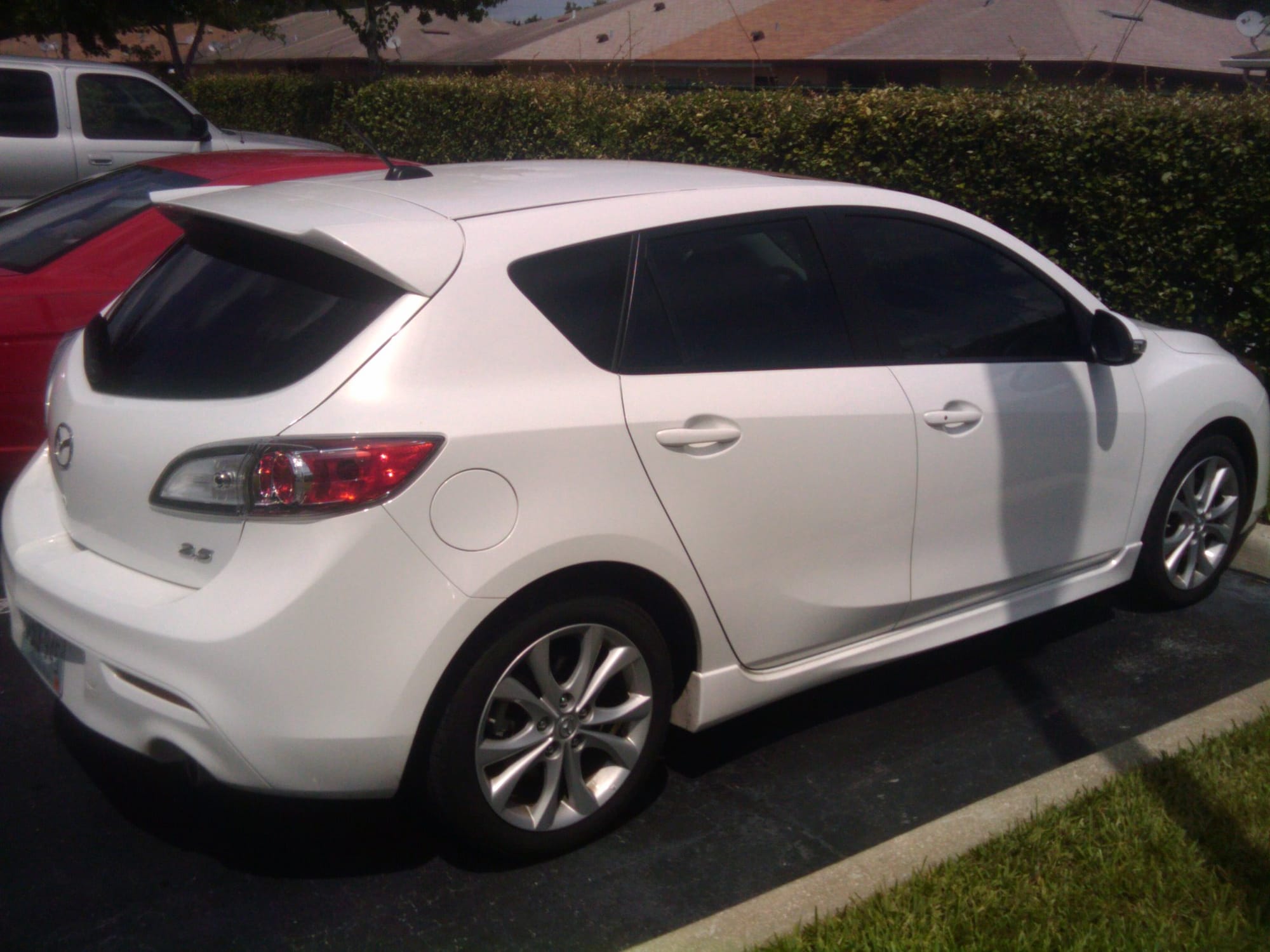 a white Mazda 3 hatchback parked outside a Florida apartment