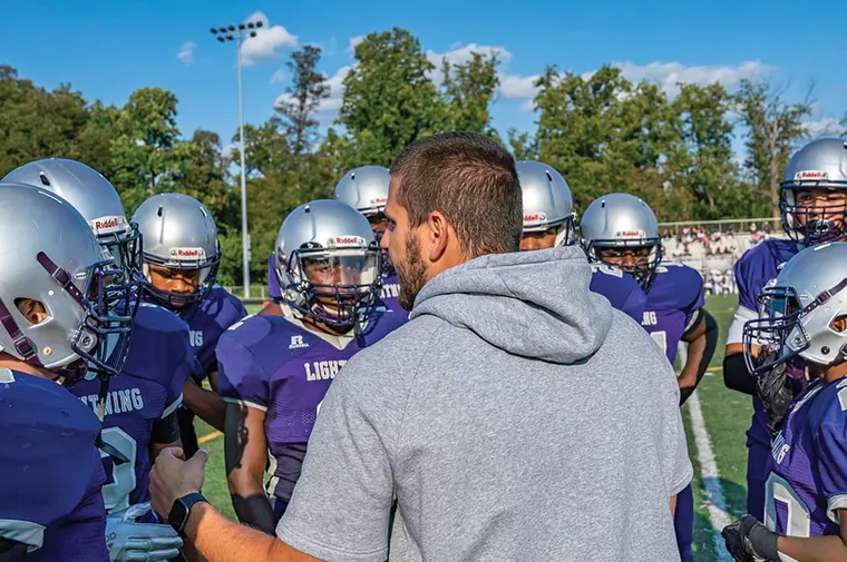 A coach talking to his football players during a game