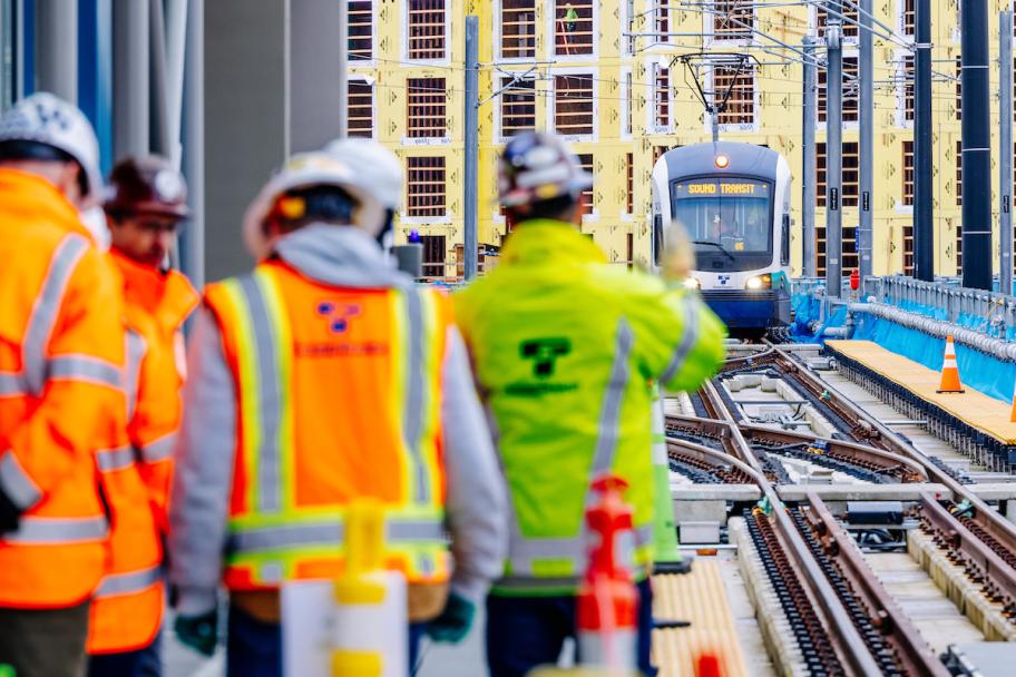 Five workers in hard hats and bright vests tour the Lynnwood Link Extension.