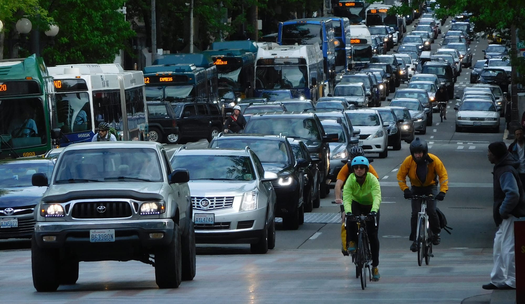A snarl of car traffic on 4th Avenue with transit and people biking on the margins. (Photo by Scott Bonjukian)
