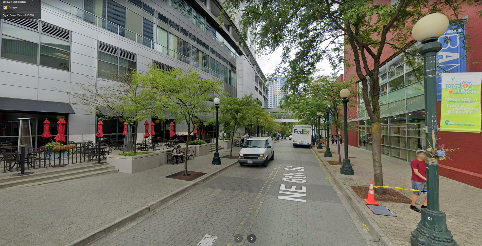 A photo of a narrow street flanked by wide sidewalks and commercial buildings.