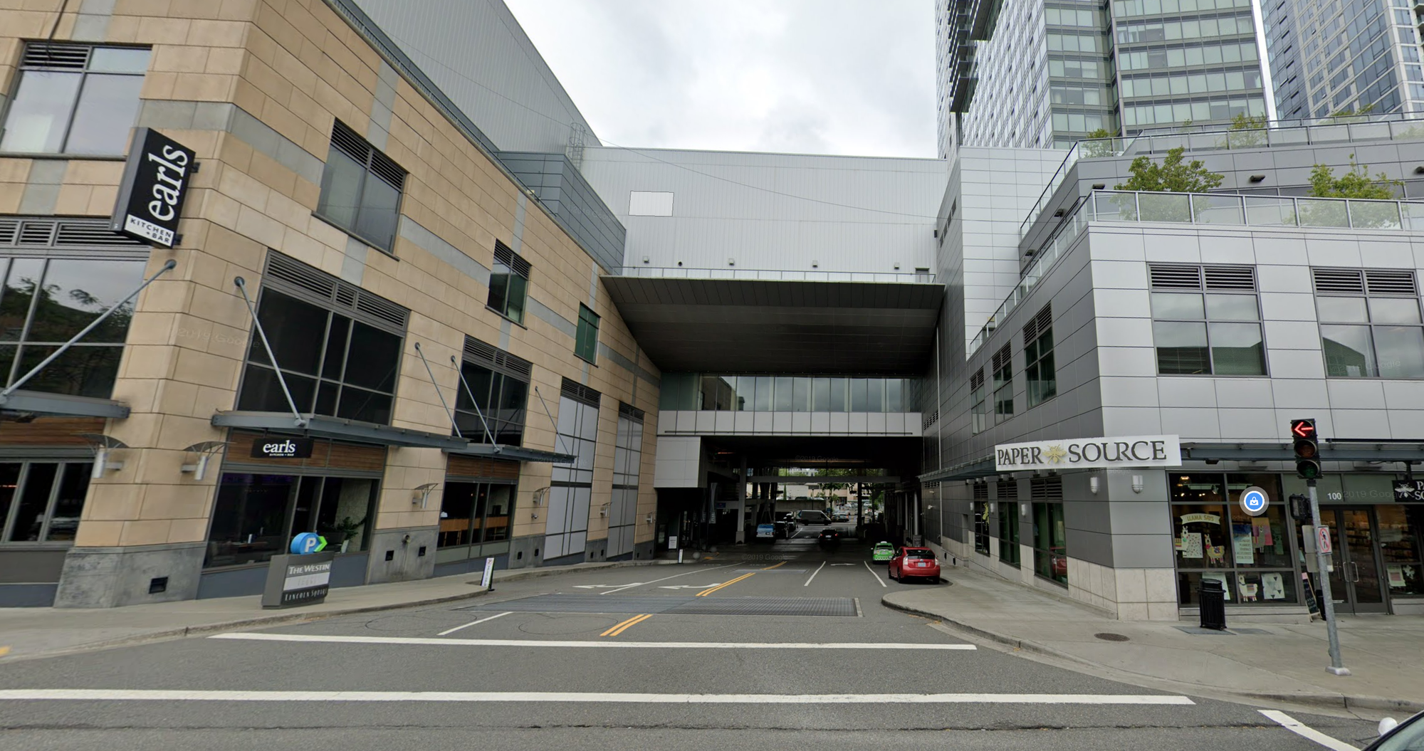 A photo of an intersection between two commercial buildings connected by a skybridge.
