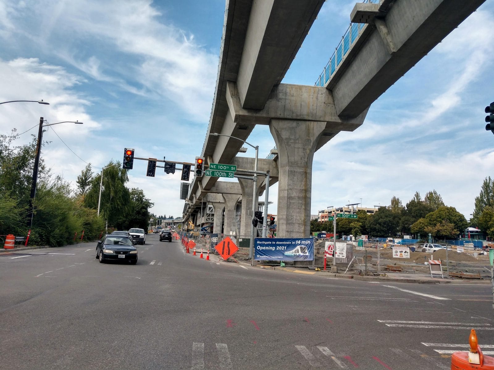 
                     Elevated light rail with pylons next to a street in Northgate.
                     