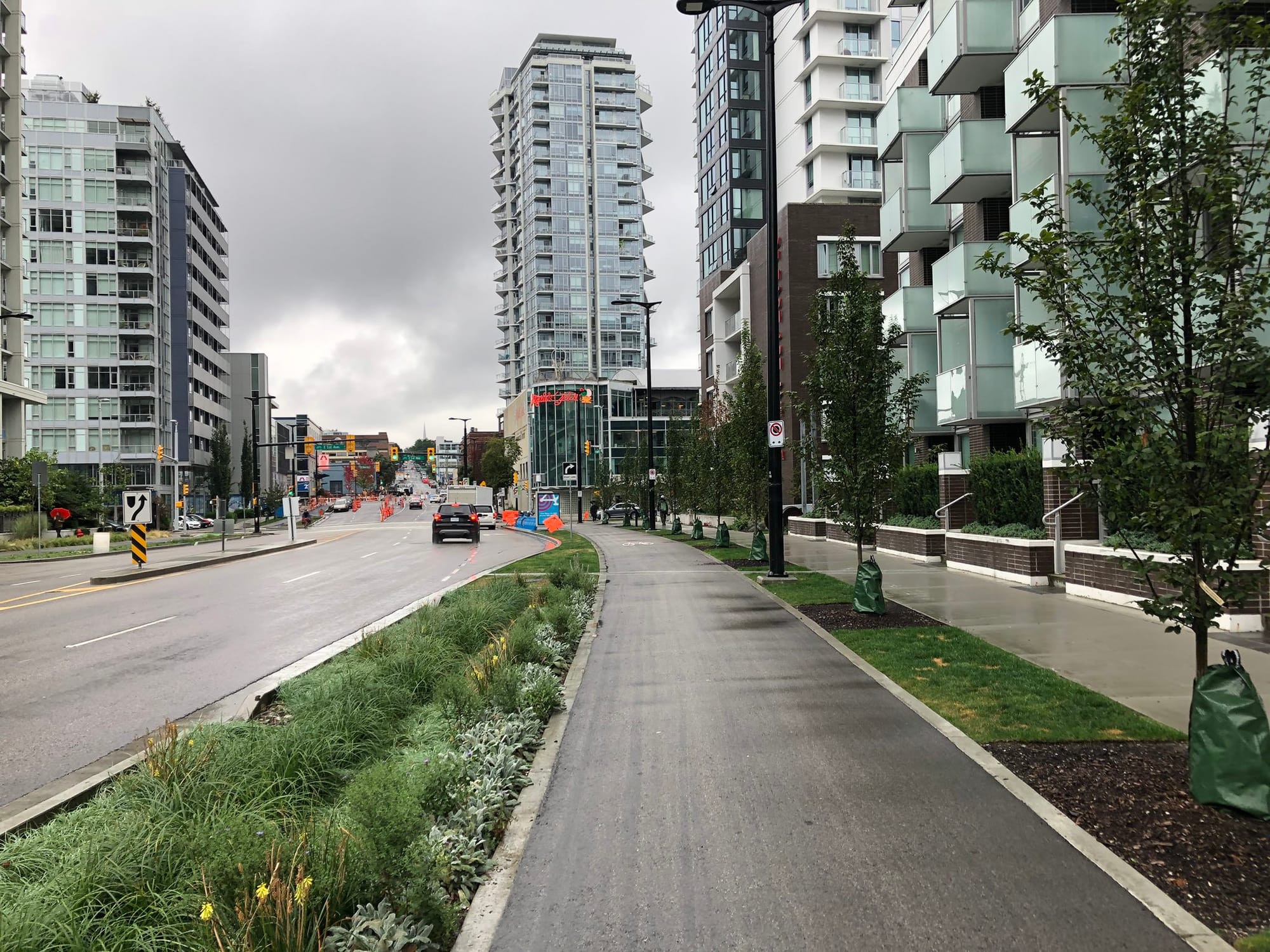 Quebec Street is a right-of-way wider than Aurora but features sidewalks with landscape buffers, protected bike lanes, and engaged street frontage. (Image by the author)
