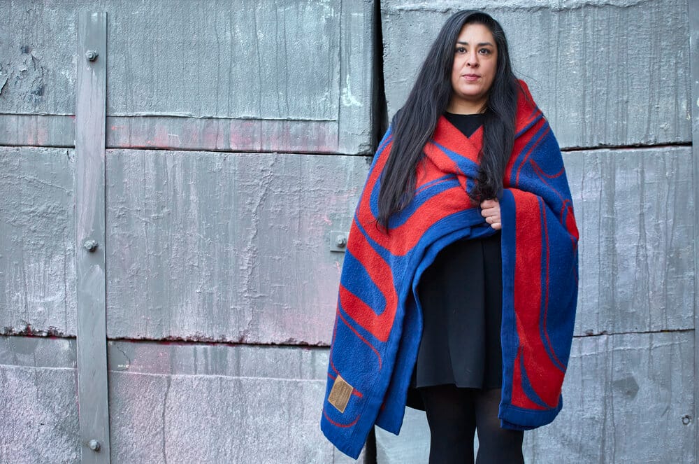 Colleen Echohawk where a blue blanket with red design.