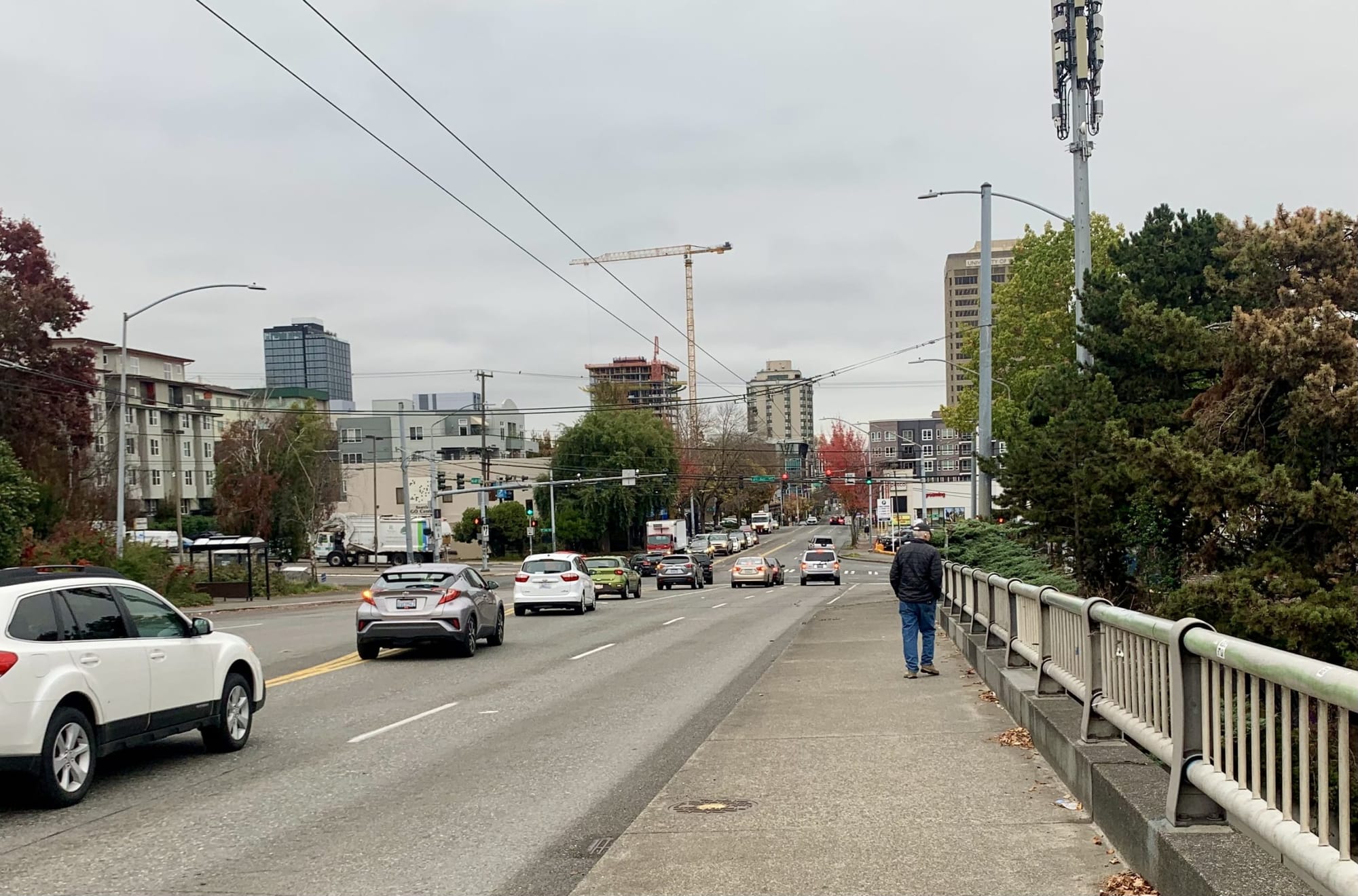 
                     A photo of a sidewalk next to a busy roadway.
                     