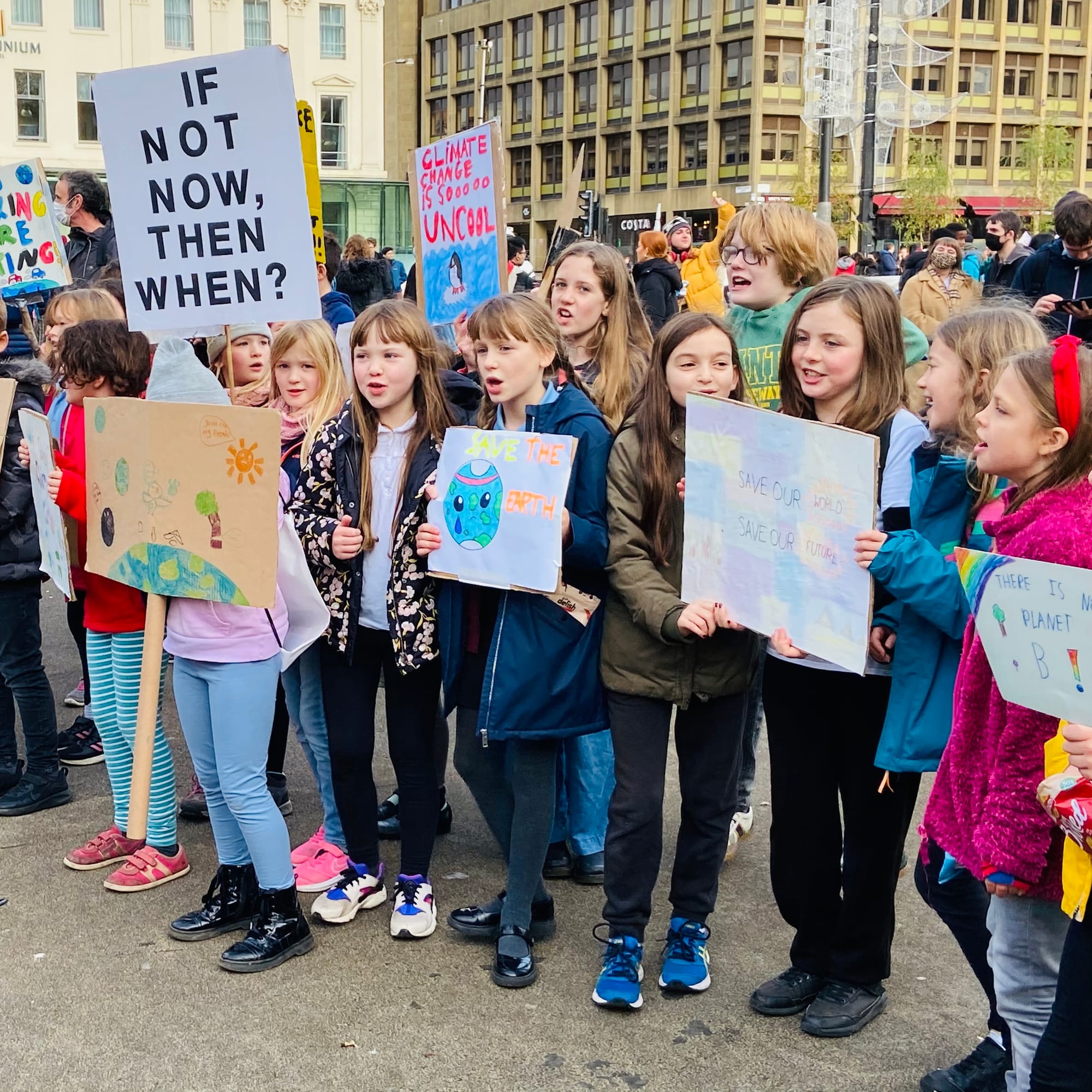 A photo of children holding signs that demand action to fight climate change.