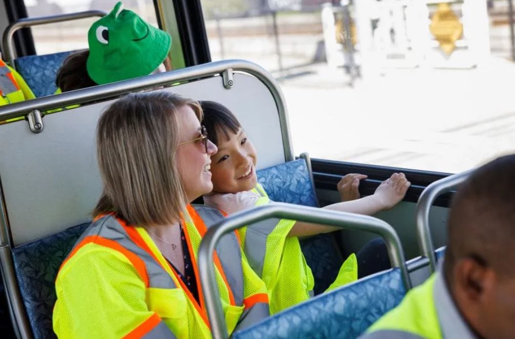 Allison and her elementary age daughter are in bright yellow safety vests aboard a Metro bus.