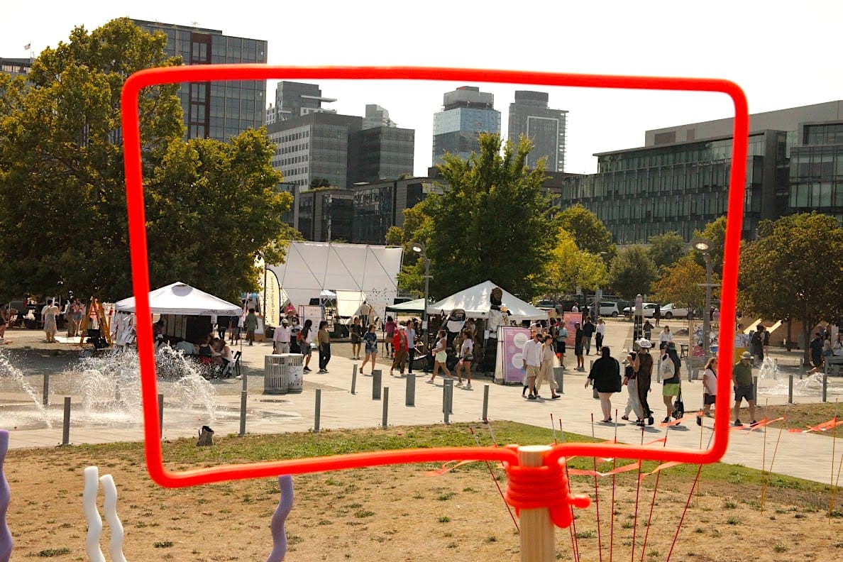
                     Looking through a discussion bubble frame at the Block Party activities with the skyline behind.
                     