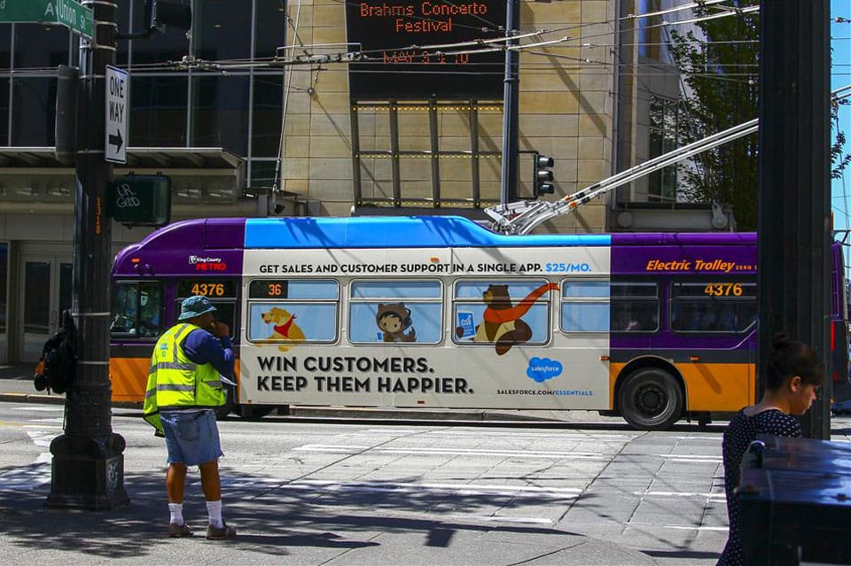 A Salesforce ad shows animated cartoon animals riding the bus with the caption "Win customers. Keep them happy."