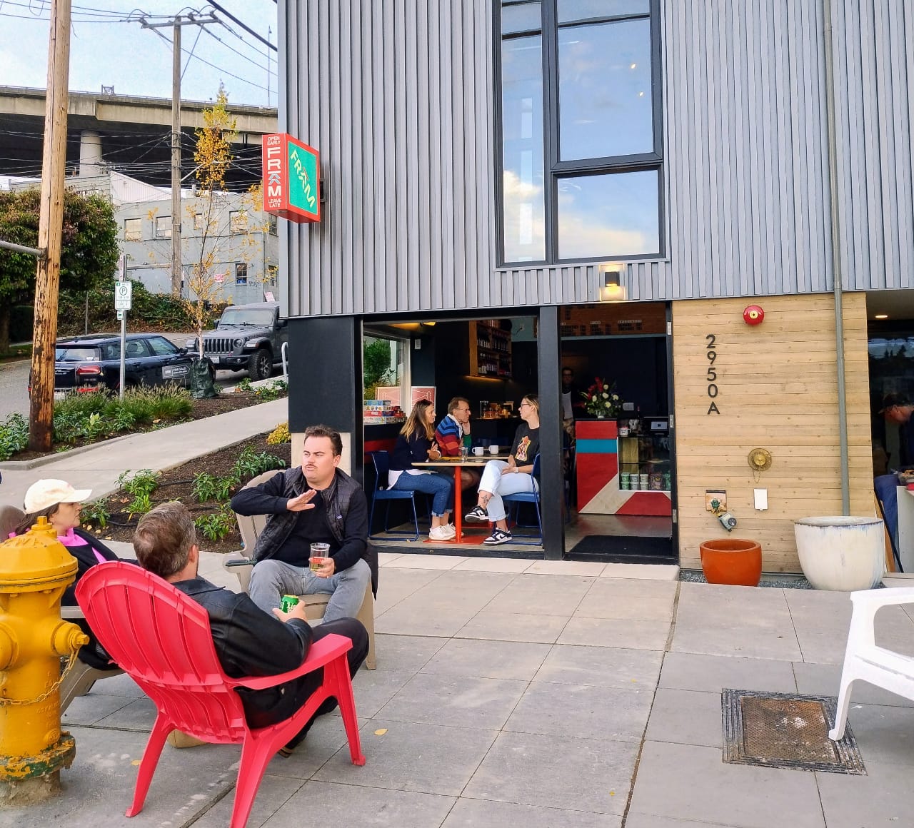A small neighborhood cafe commercial storefront with people sitting outside in patio chairs