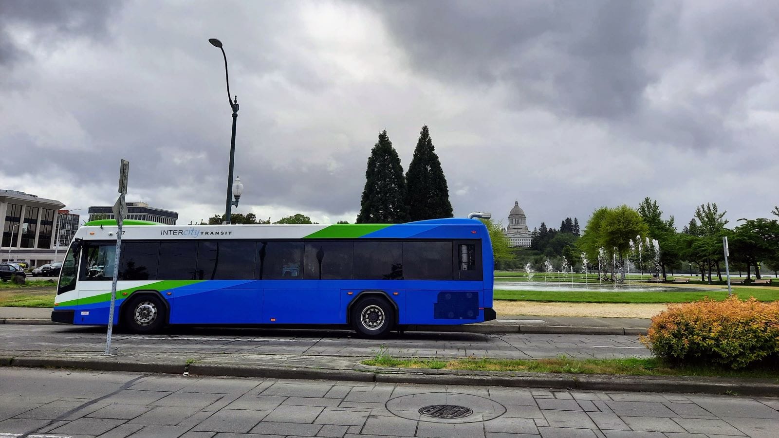An Intercity Transit bus next to the Capitol lawn fountain with the dome in the background.