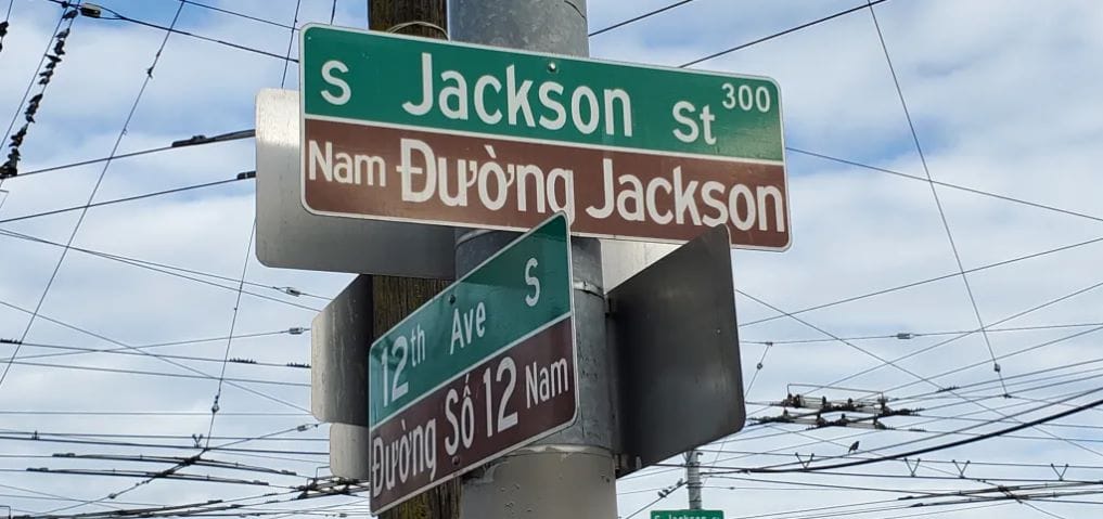 The street signs name the streets in English and in Vietnamese.