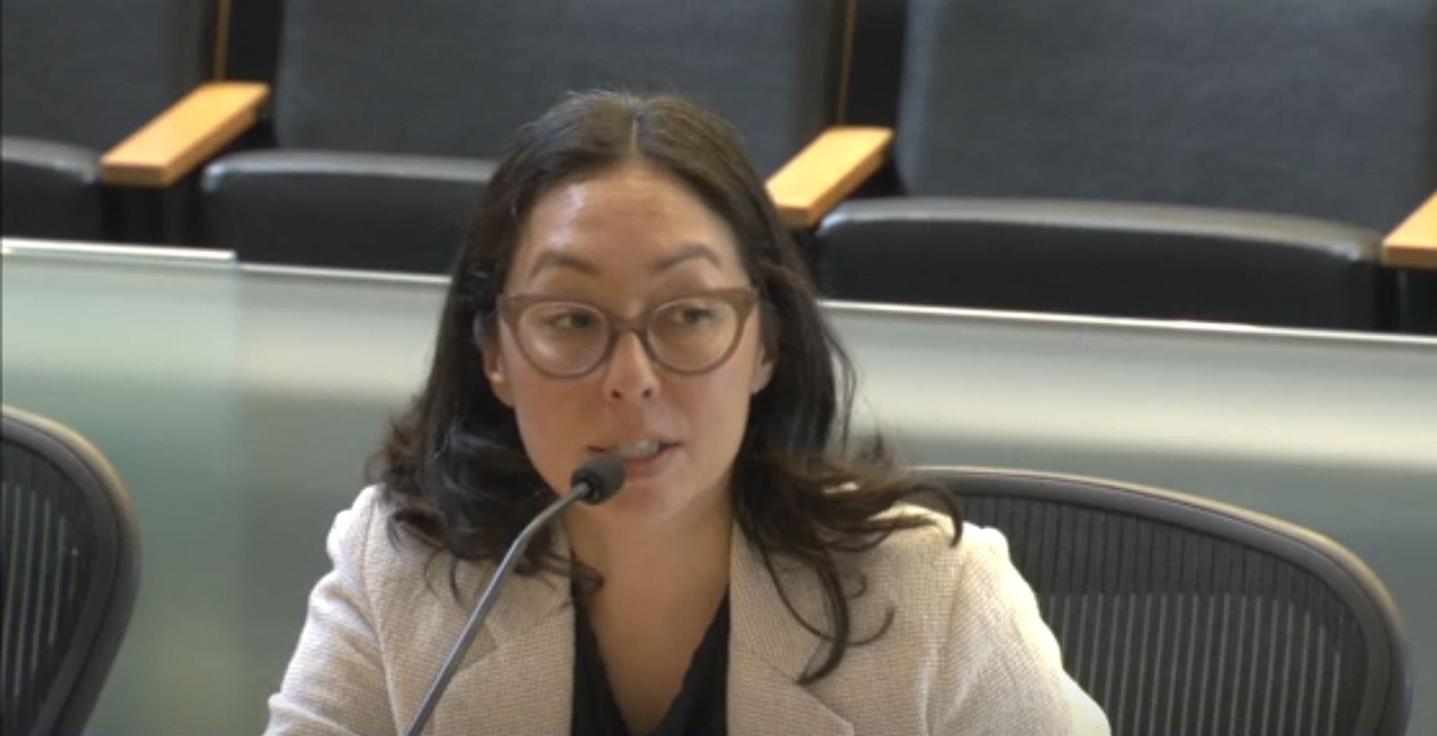 Castellanos has dark hair and dark glasses and wears a cream-colored blazer.