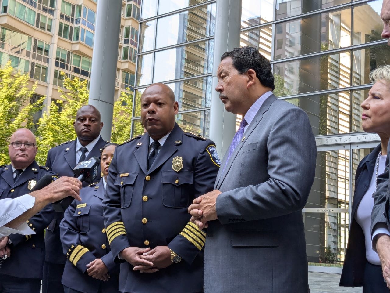 Officials stand on the steps of Seattle's US Courthouse after the consent decree hearing.