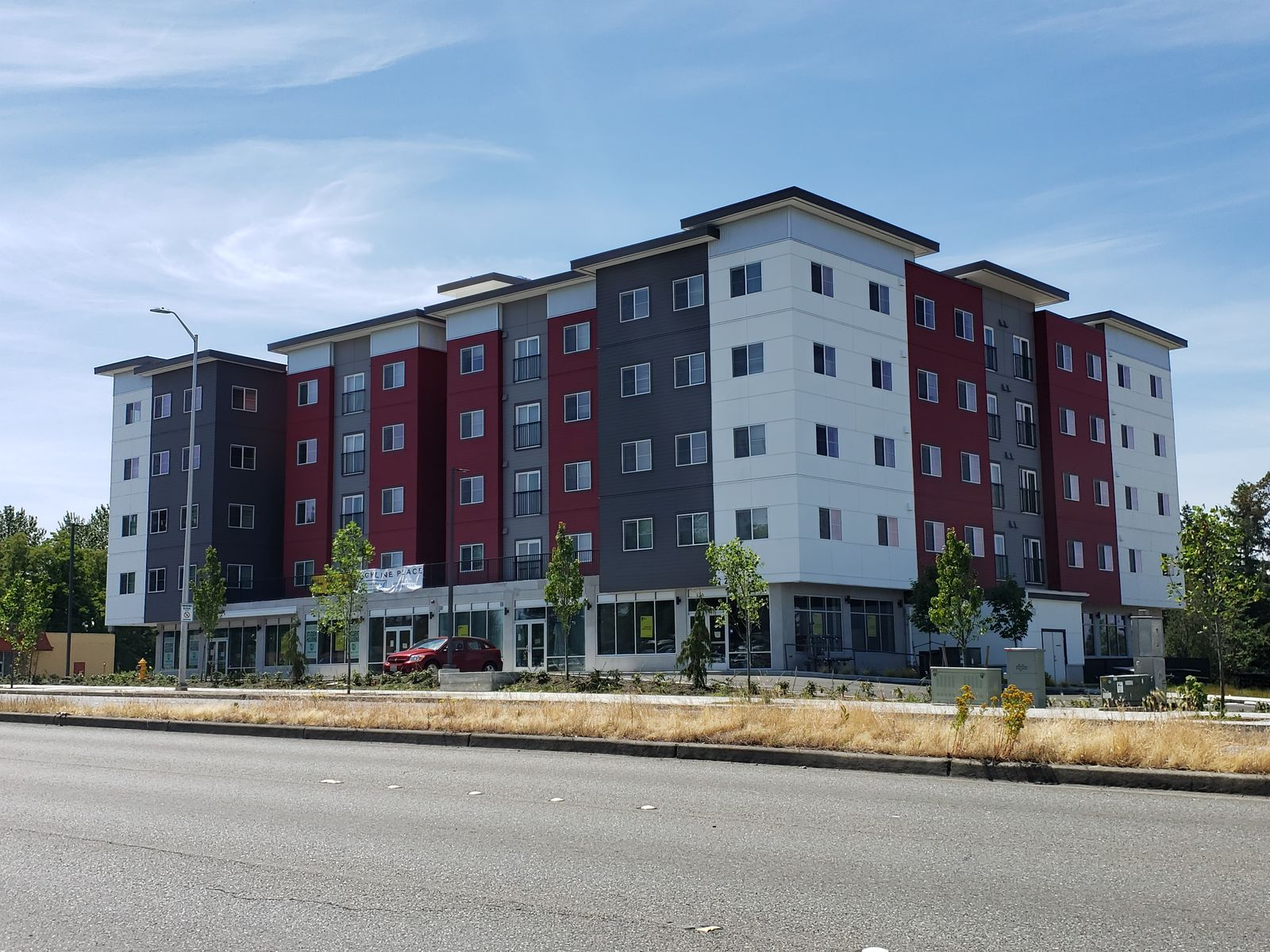 A five story apartment building along a wide arterial street.