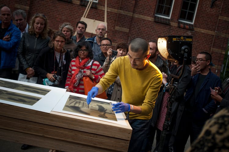 Photographer Daisuke Yokota in a book performance at Amsterdam's UNSEEN photo fair, in 2014.