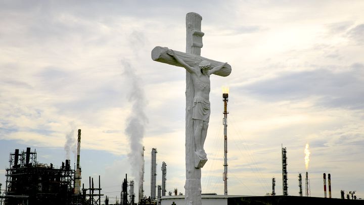 A cross in a cemetery stands near a petrochemical manufacturing plant on August 21, 2019 in Hahnville, Louisiana.
