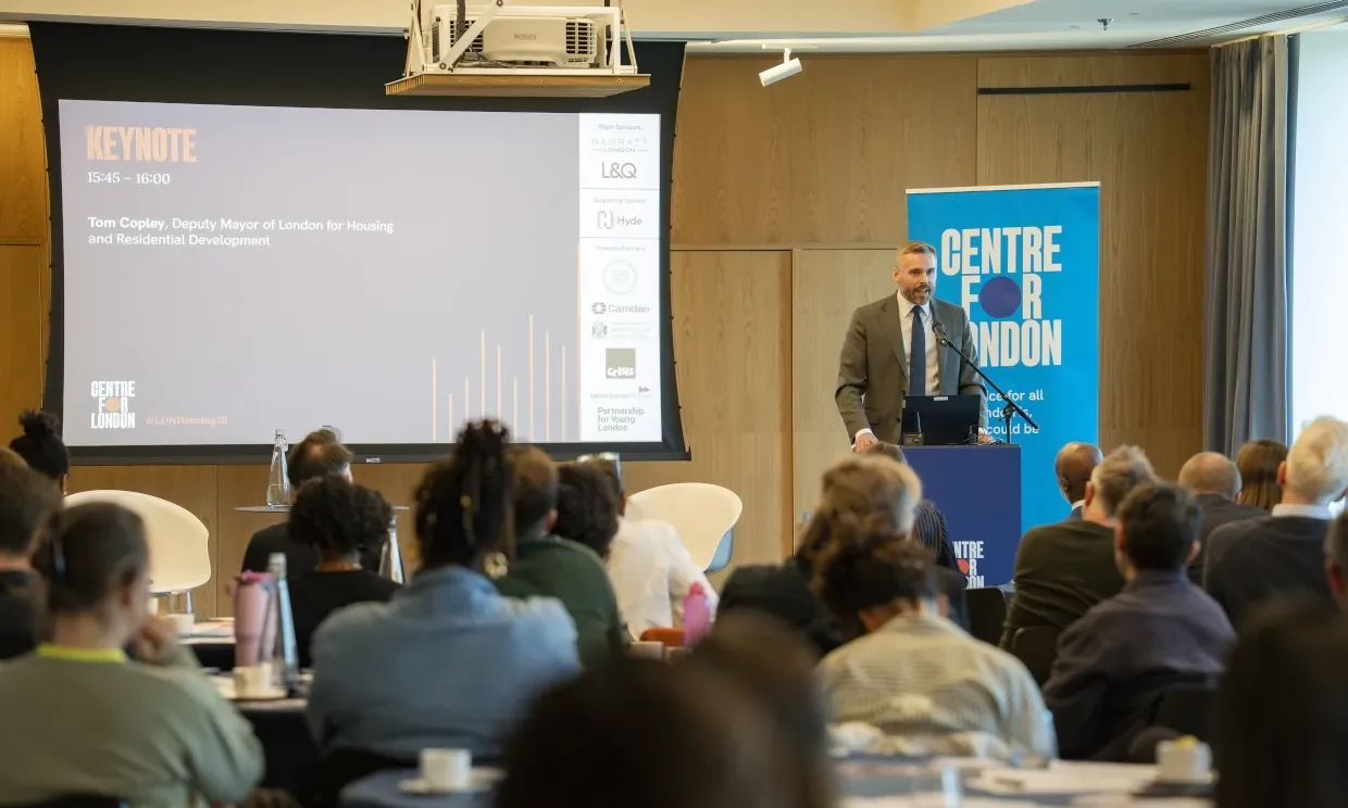 Tom Copley speaking to a large room of people