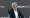 Sadiq Khan sits at a desk with a microphone in front of him