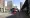 Outside Canning Town station, there are two double decker red buses on the street