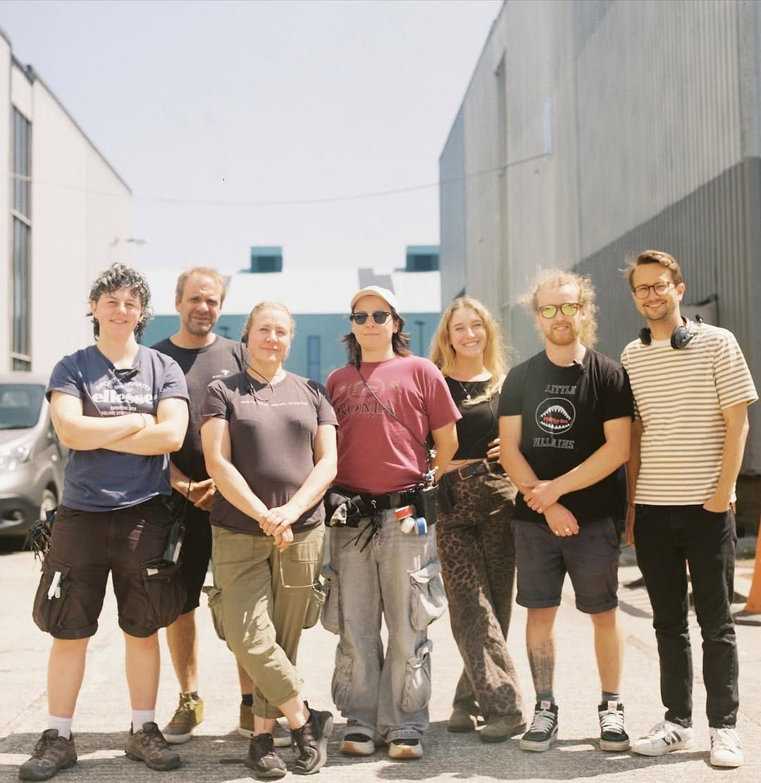 Seven crew members standing together facing camera