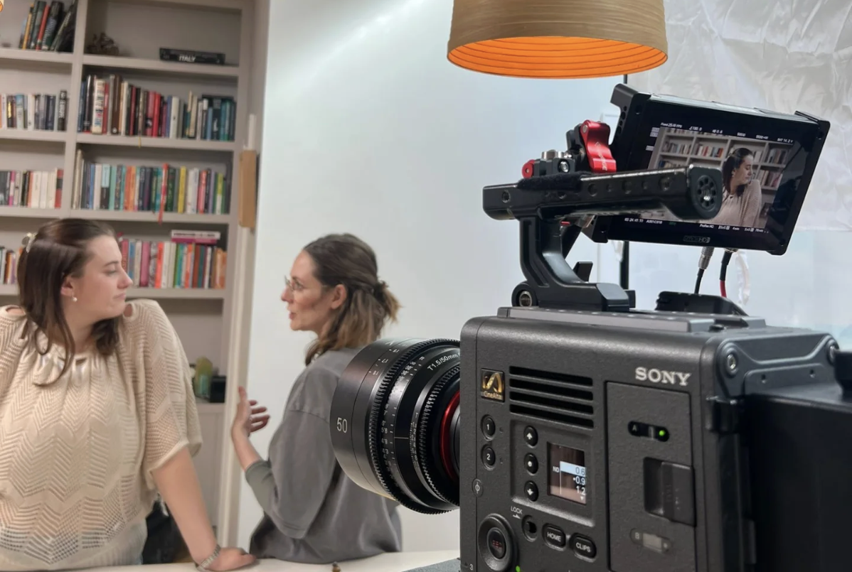 Two people talking in front of a camera in the living room.
