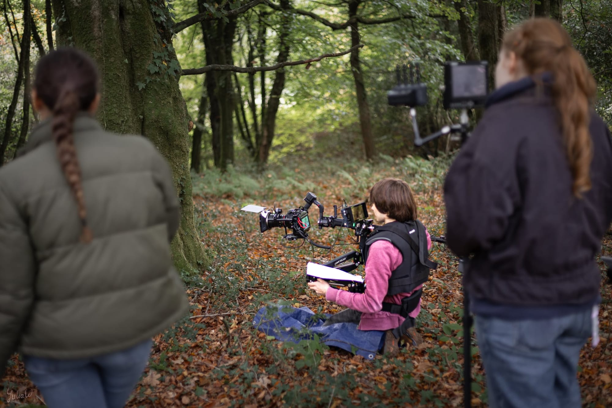Three camera department filmmakers in a forest.