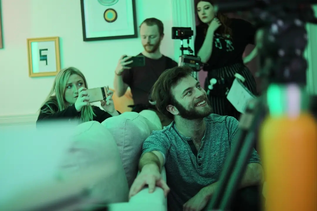 Filmmakers looking at monitors in a living room set.