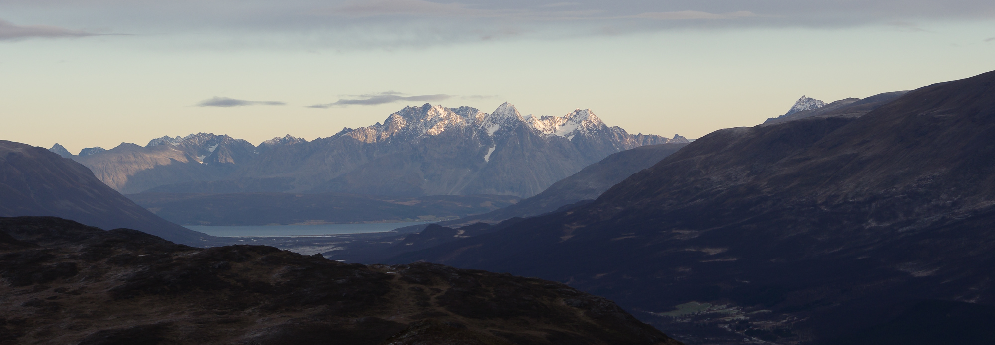 Midday sun shining on the peaks of Lyngen in the distance.