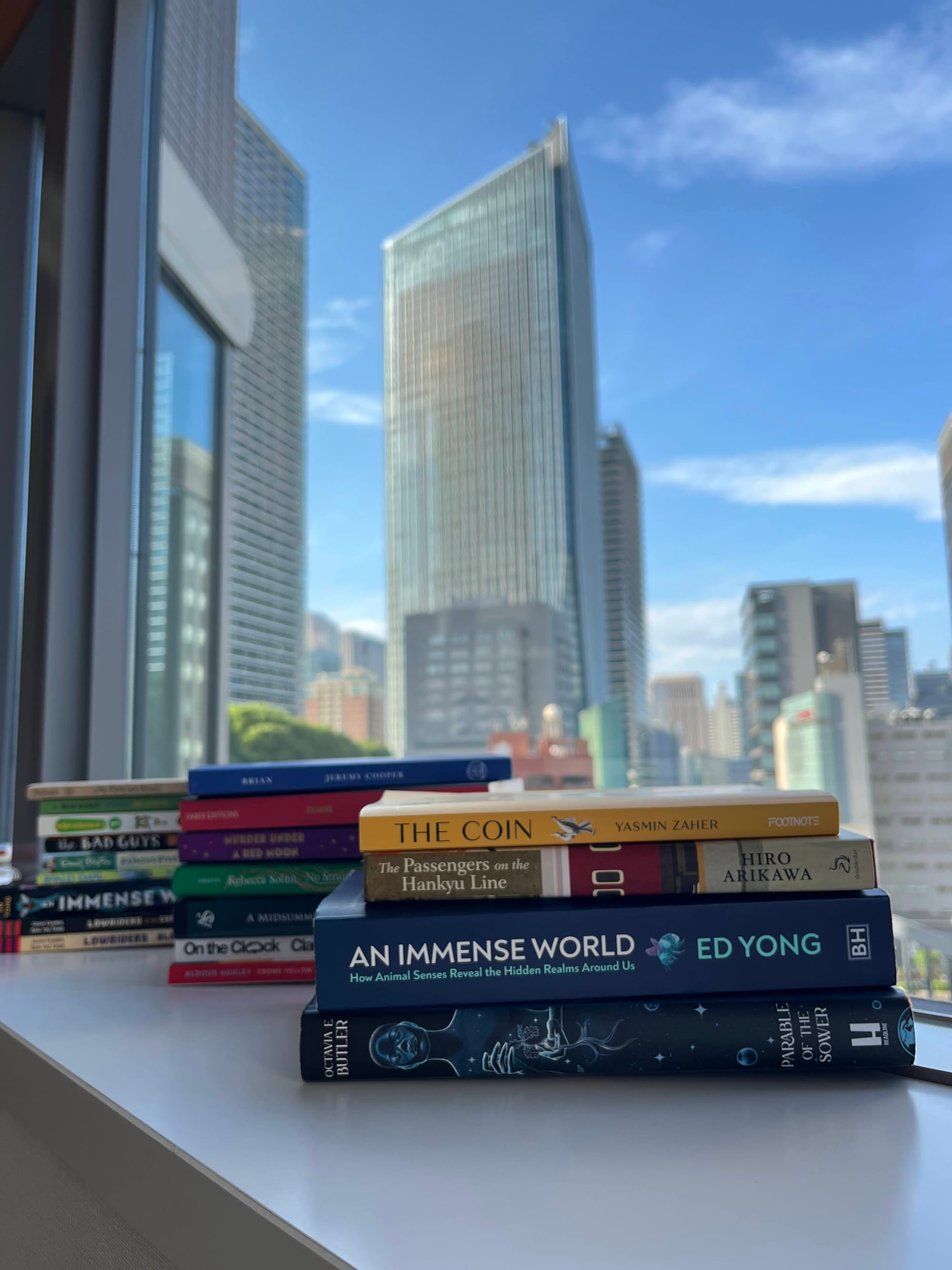 Three stacks of books in the foreground. Tokyo's skyline in the background.