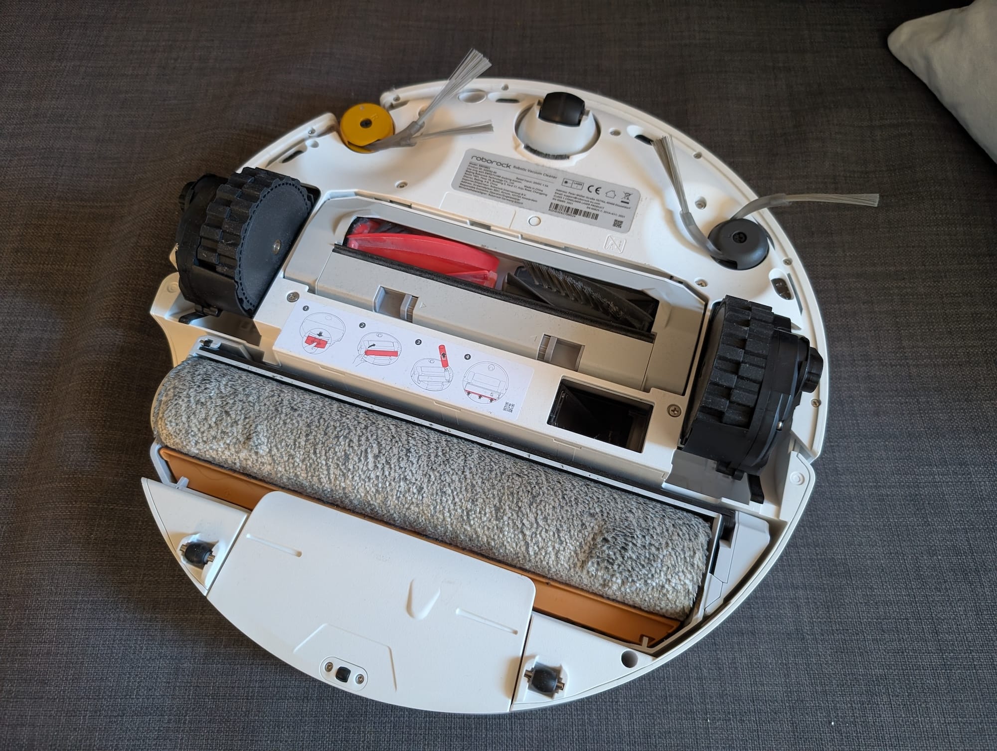 Dem Robo unter den Rock geschaut: Vorne die zwei Bürsten, mittig Walzen zum Einsaugen und unten die Mopprolle fürs feucht aufnehmen.