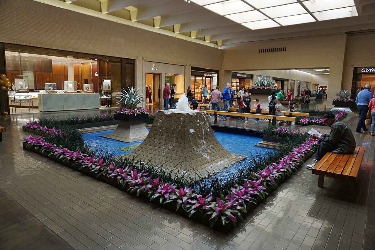 Interior fountain court at NorthPark Center in Dallas, showing the custom cream-white brick, tiered fountains and skylights.