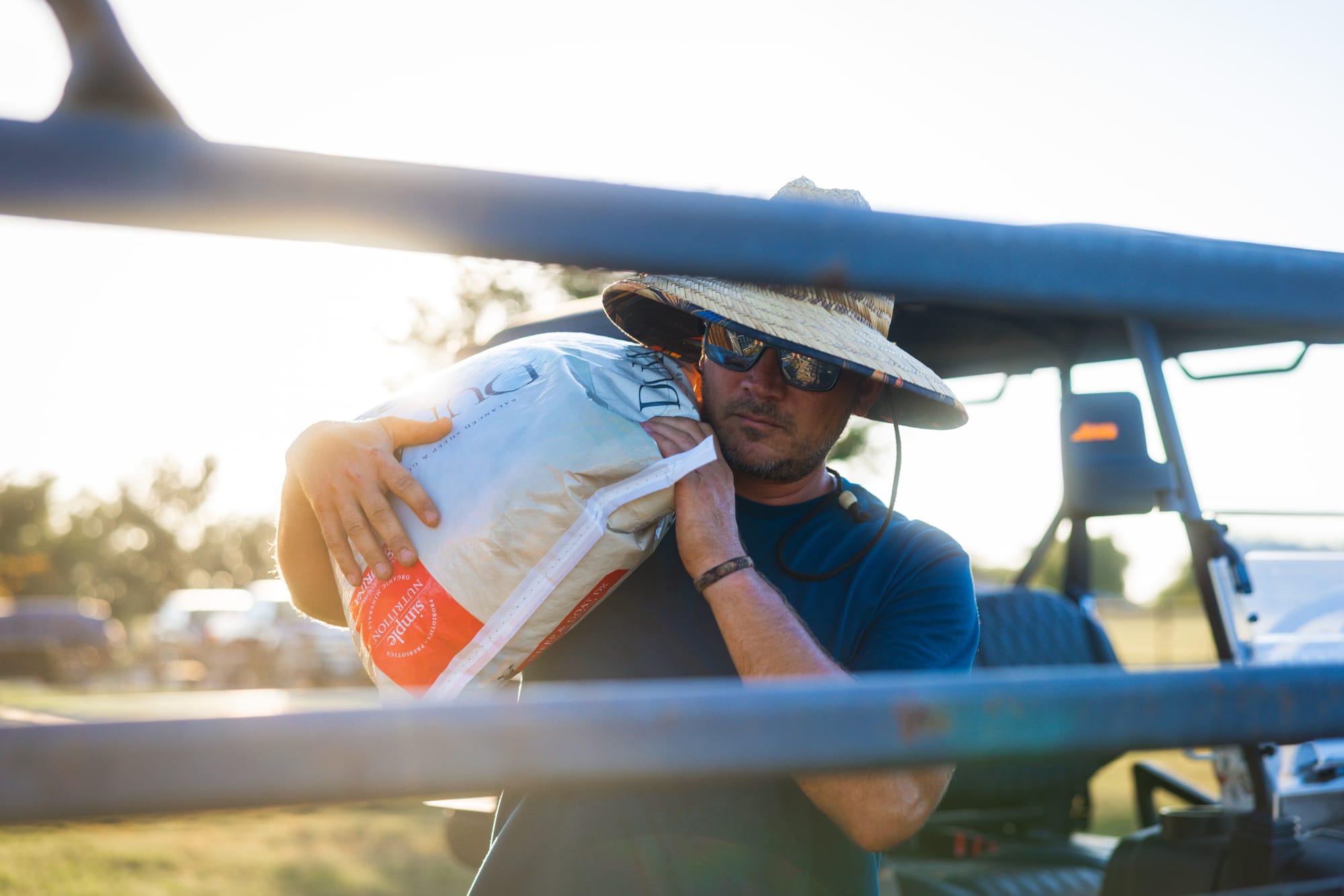 Justin carries a bag of feed on his shoulder during morning chores