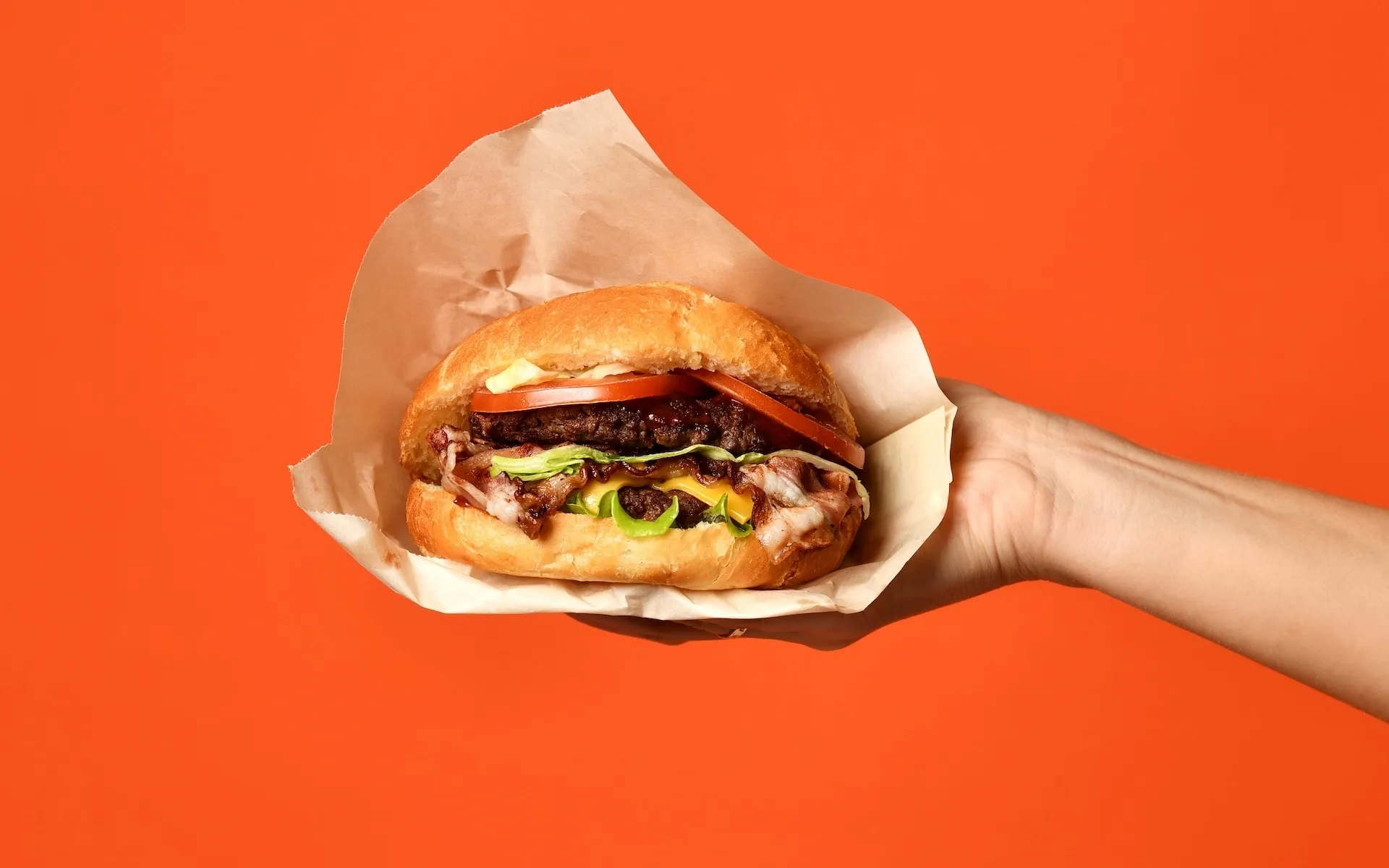 Hand holding a burger 