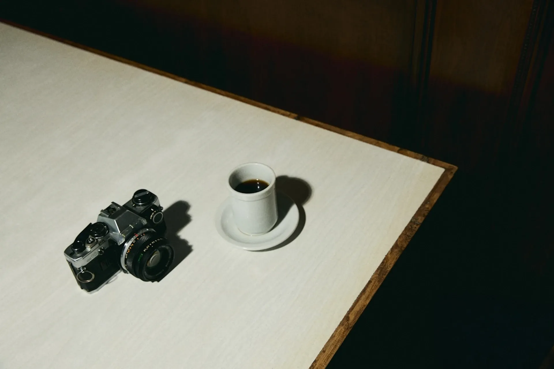 A camera and a cup of coffee on a table