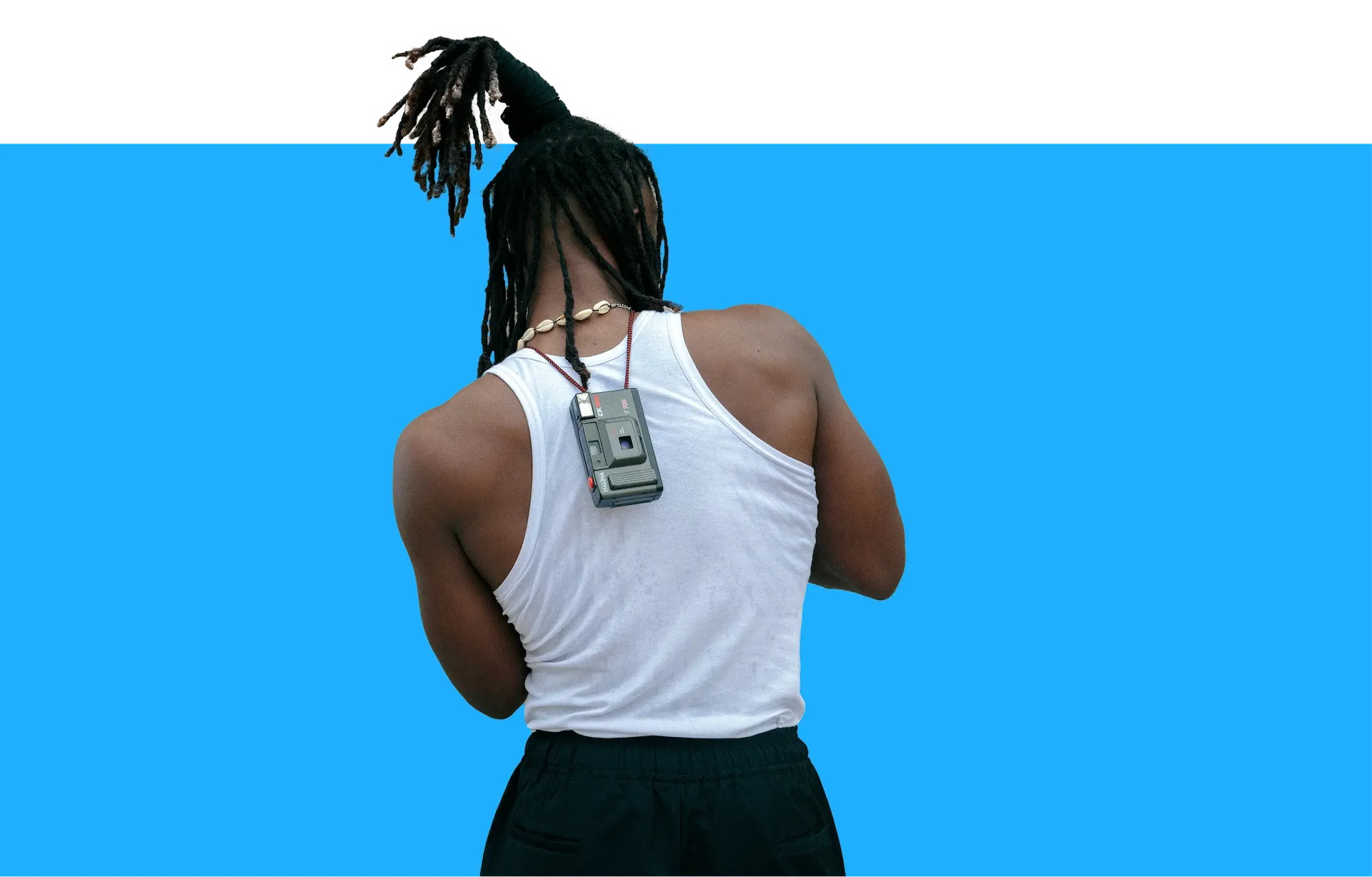 Man wearing a sports vest with a camera around his neck