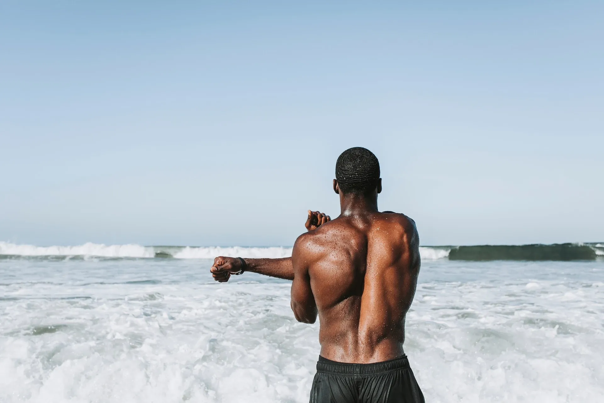 Man stretching his arms in front of the sea