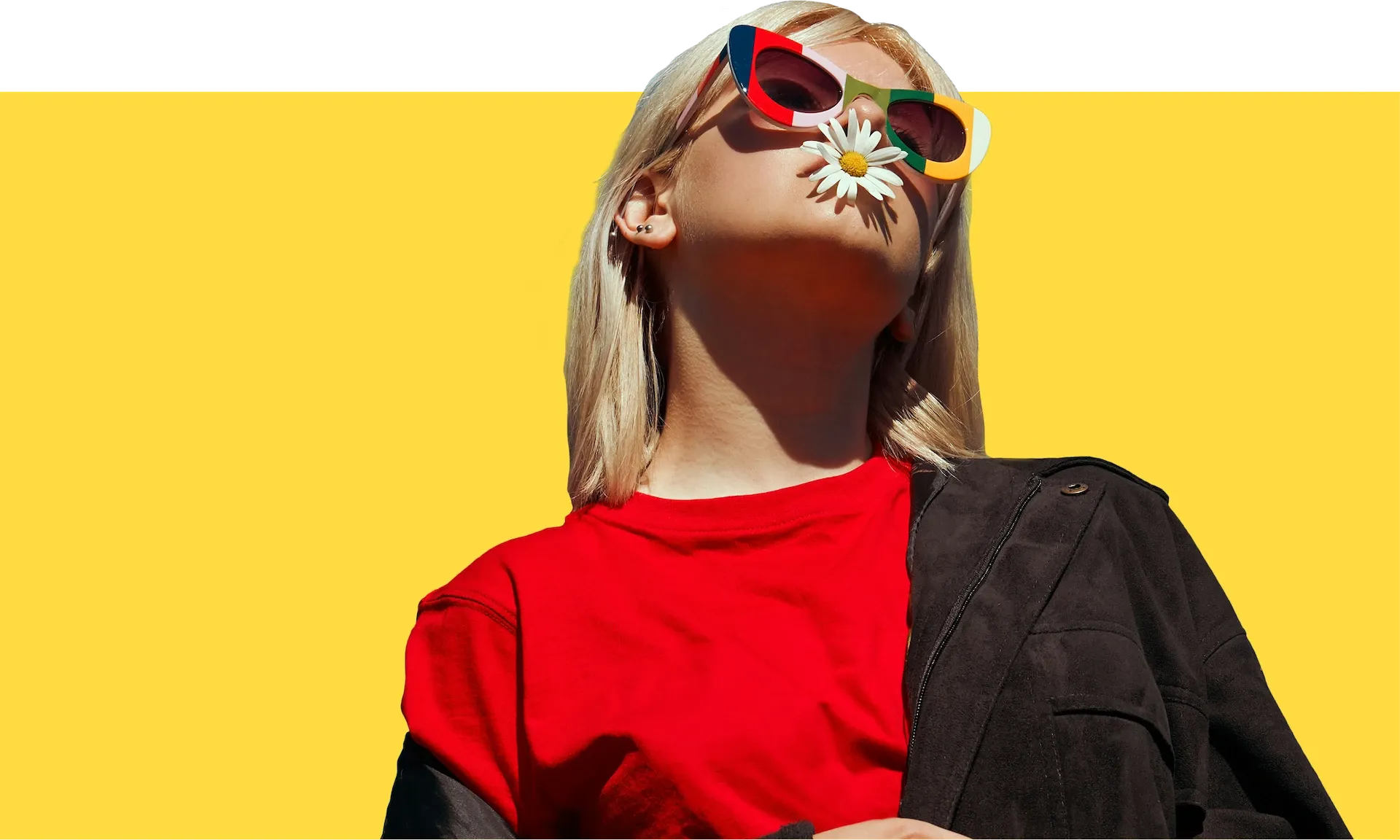 Woman wearing sunglasses with a flower in her mouth