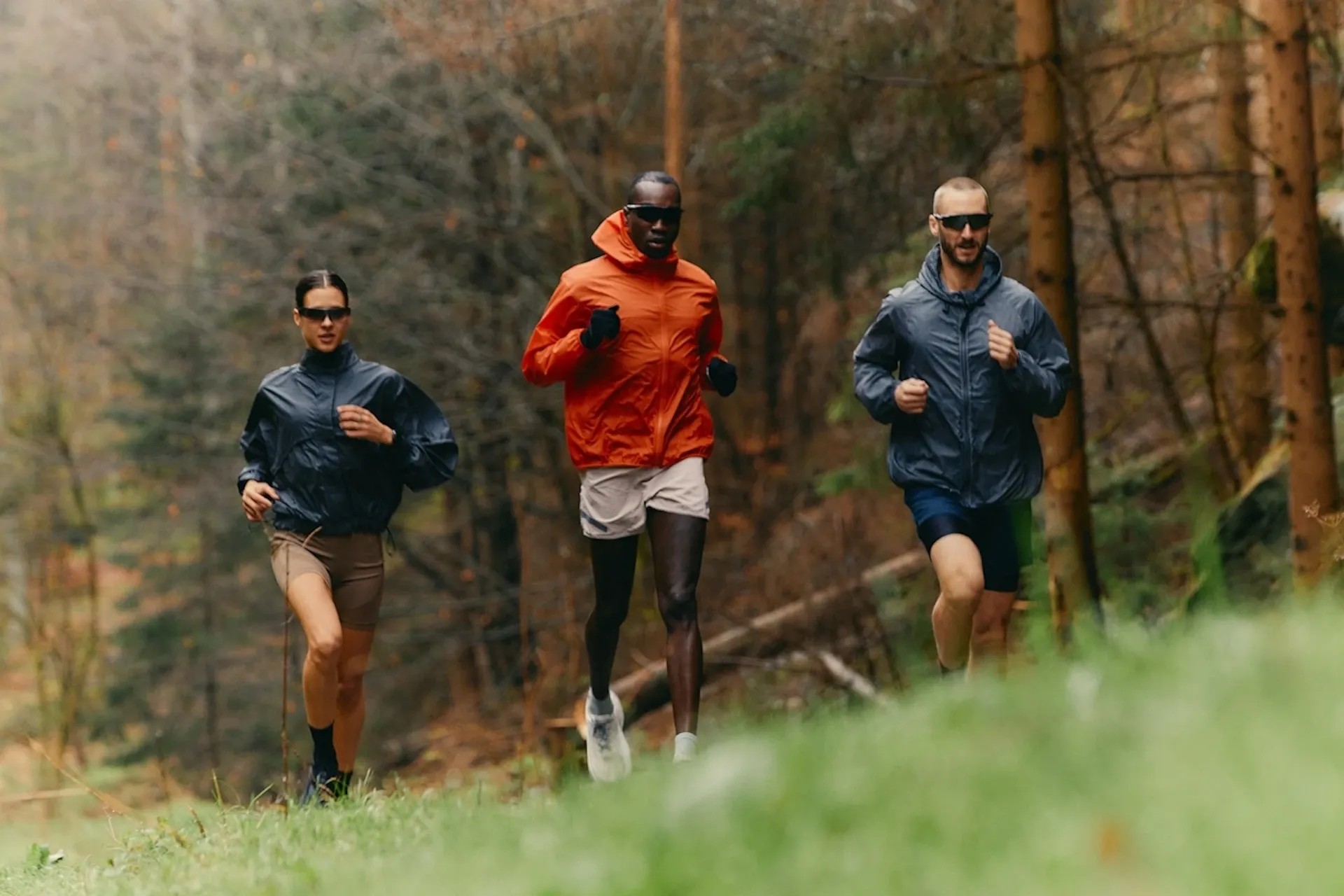 Three people jogging through a field